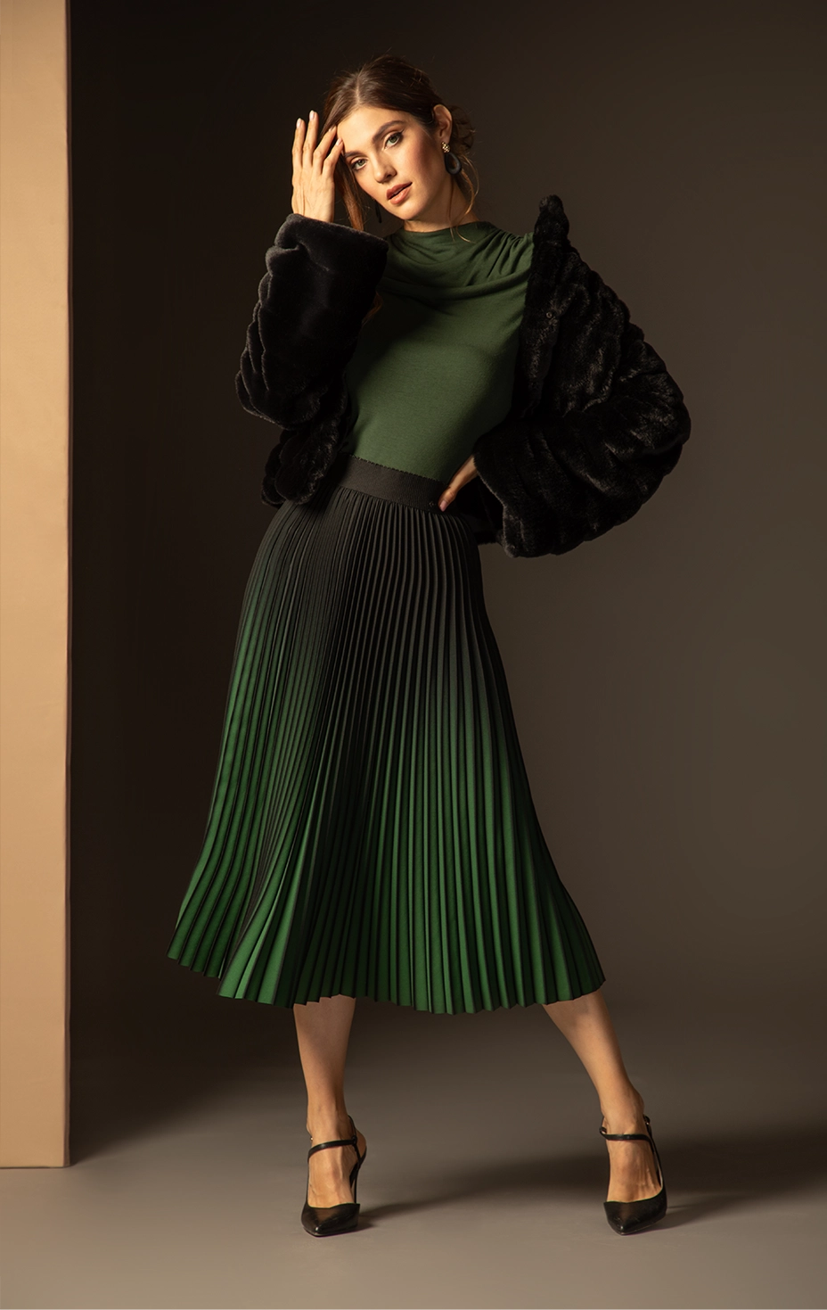 Dika look with black faux fur jacket, draped green top and pleated midi skirt – Shop the Look