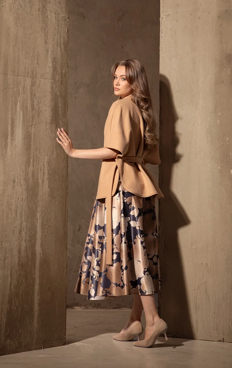 Elegant women’s look with beige wool coat and floral print midi skirt